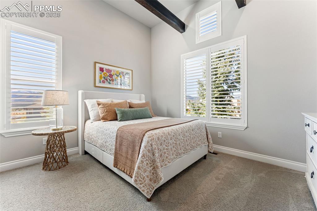 Image 27 of 50: Second main level bedroom with large windows and high ceilings