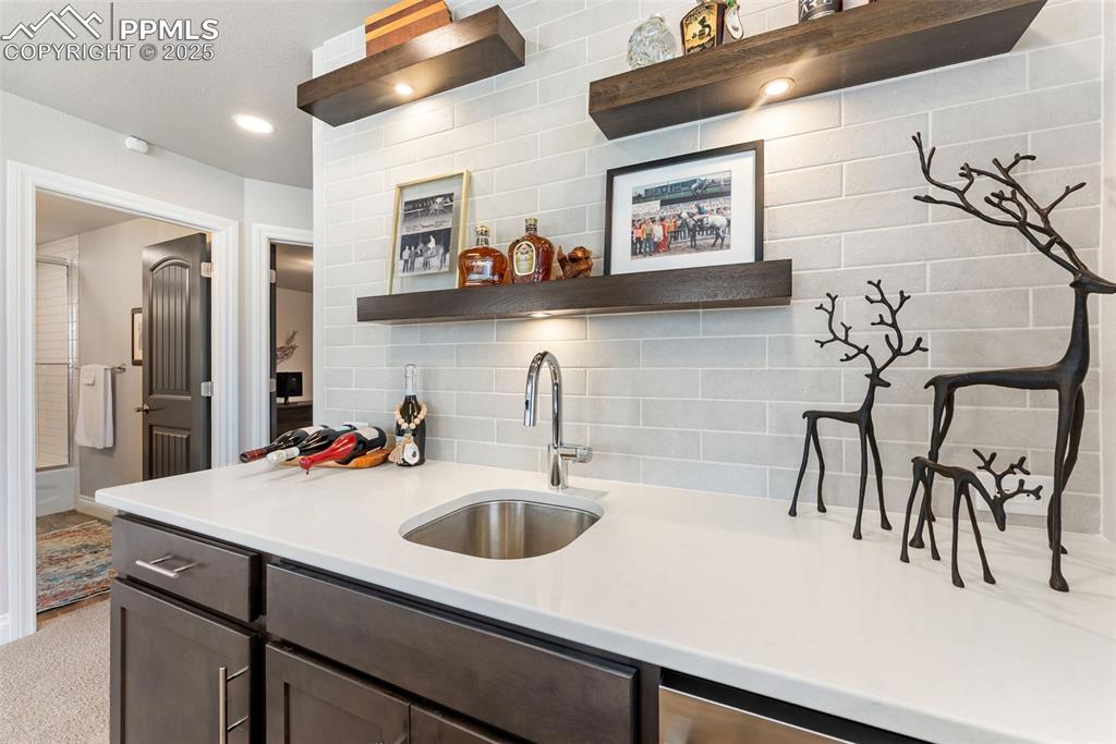 Image 36 of 50: Quartz countertops, stainless sink and floating shelves with built-in light
