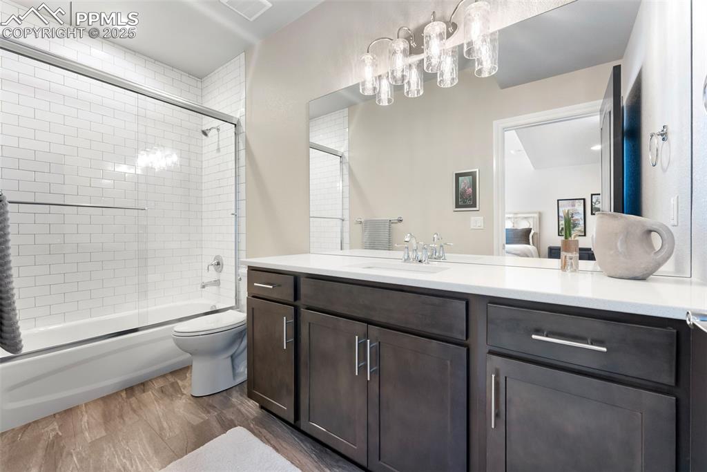 Image 39 of 50: Basement level bathroom with floor to ceiling tile shower/tub surround and