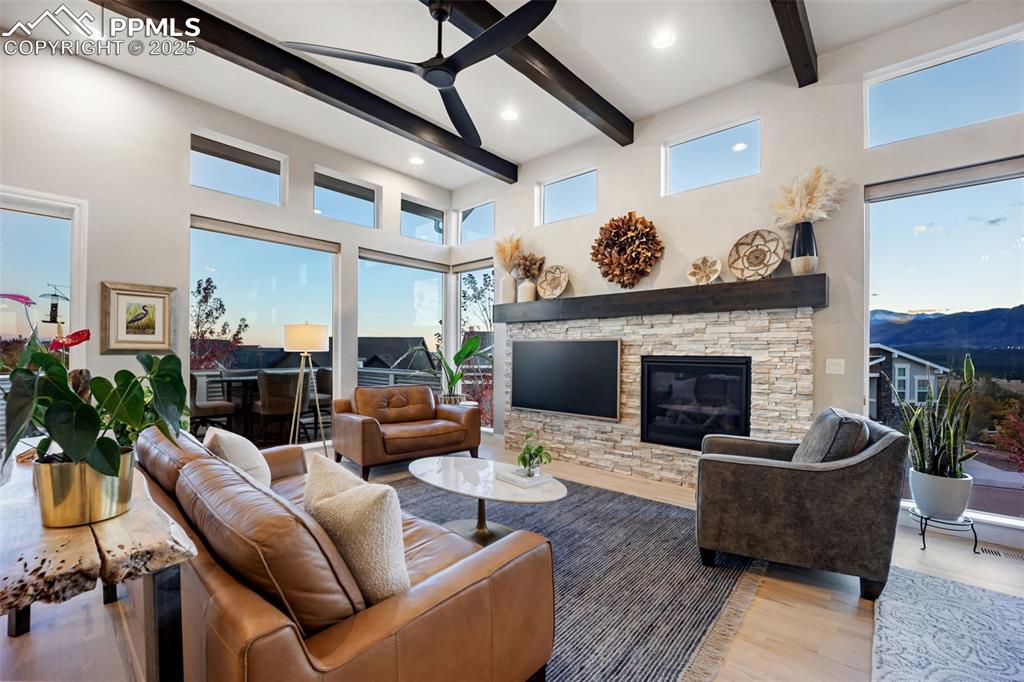 Image 6 of 50: Open-concept design and breathtaking mountain views beyond the expansive wi