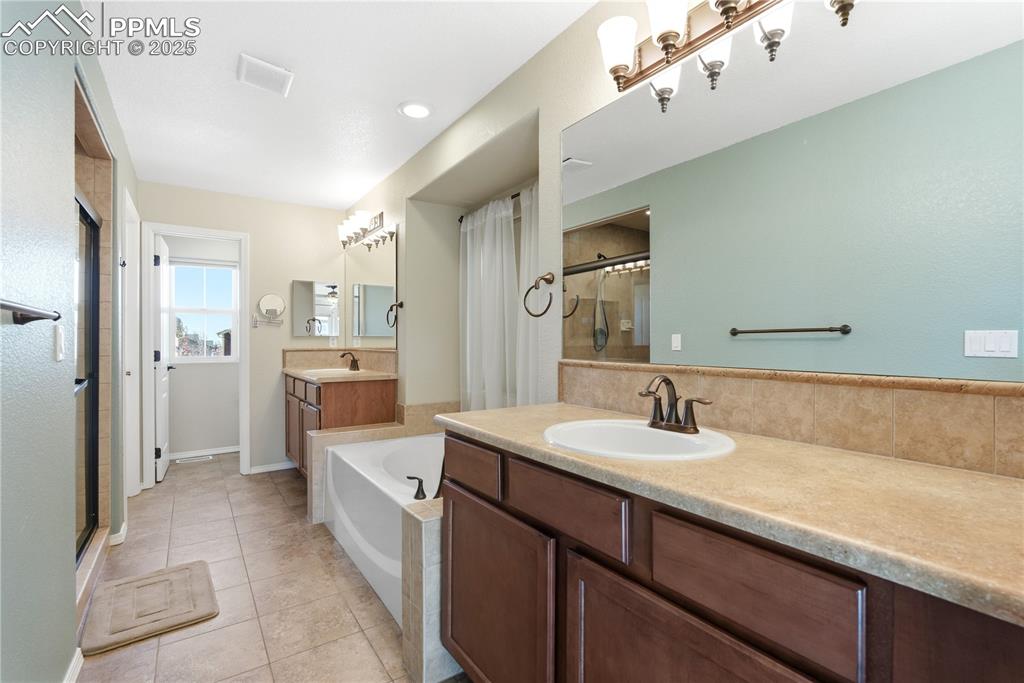 Image 22 of 42: Bathroom with a stall shower, light tile patterned floors, a garden tub, an