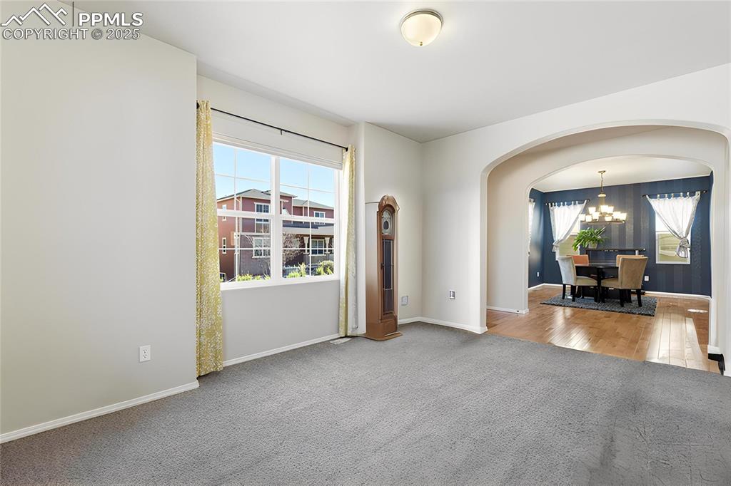 Image 4 of 42: Unfurnished room featuring arched walkways, light carpet, healthy amount of