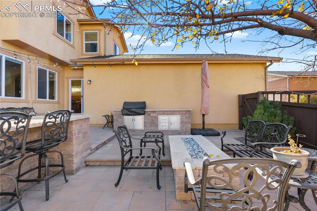Image 40 of 42: View of patio with outdoor dining space and a fire pit
