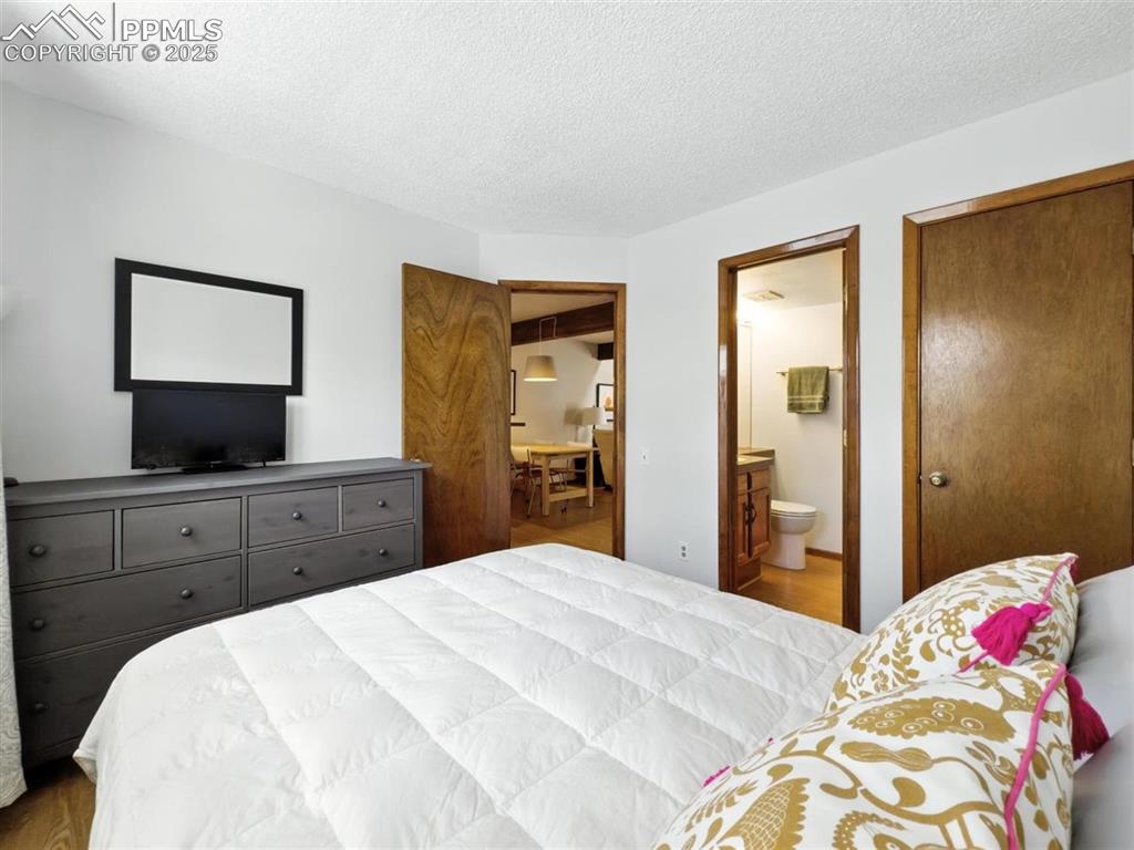 Image 11 of 25: Bedroom with connected bathroom and a textured ceiling