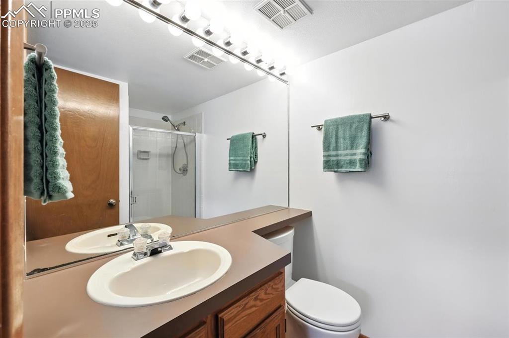 Image 12 of 25: Bathroom with a shower stall and vanity