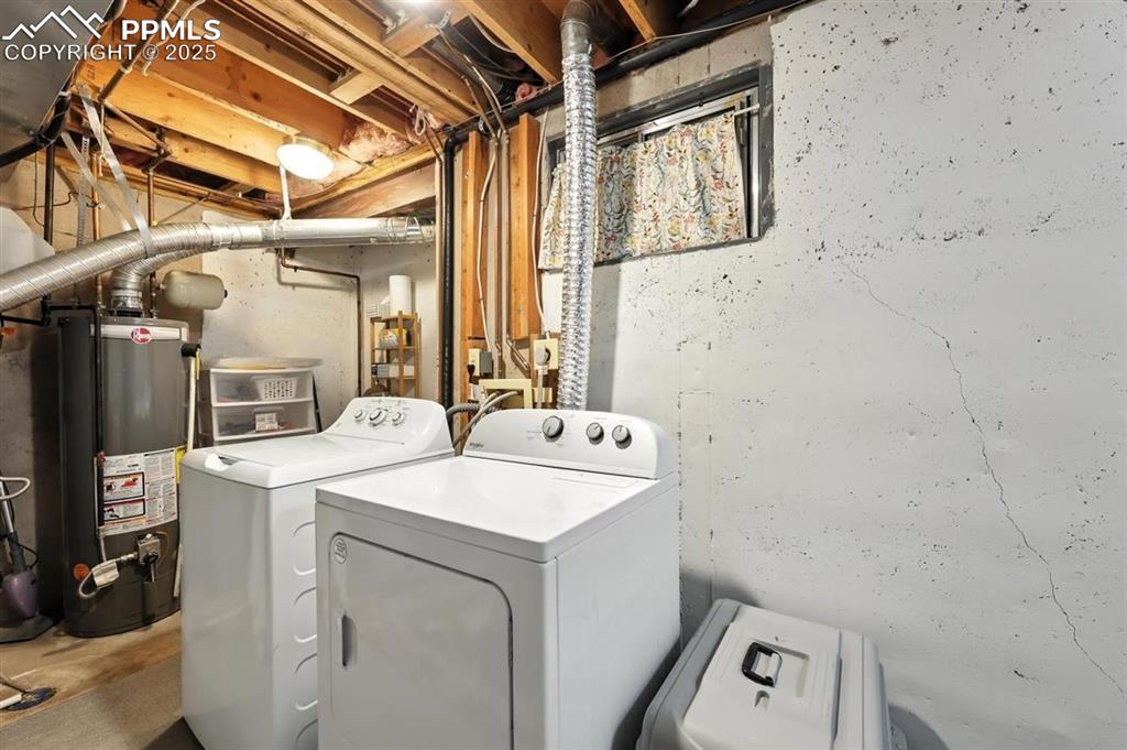 Image 19 of 25: Laundry area with washer and clothes dryer and water heater