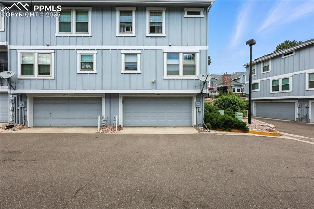 Image 20 of 25: Townhome / multi-family property with board and batten siding and an attach