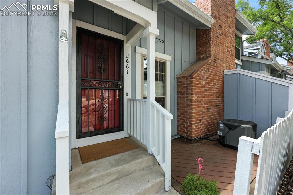 Image 3 of 25: Doorway to property with board and batten siding and a chimney