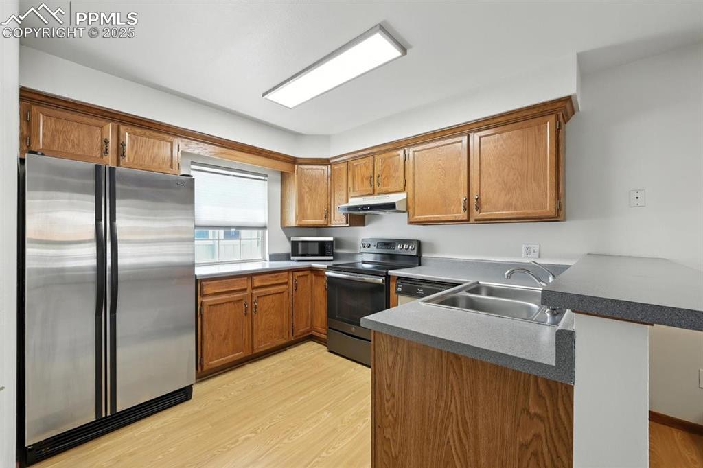 Image 7 of 25: Kitchen with appliances with stainless steel finishes, under cabinet range