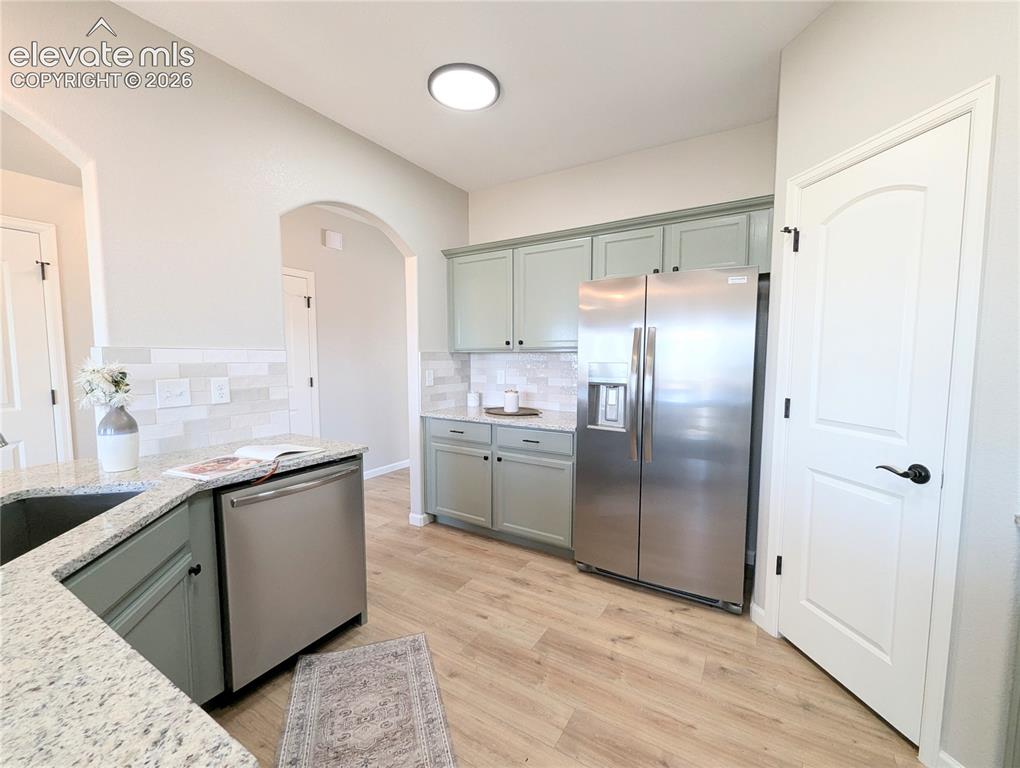 Image 11 of 49: Private water closet featuring wood-finish flooring, light tan walls, and w