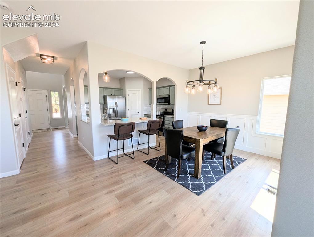Image 15 of 49: Kitchen featuring light green cabinetry, stainless steel appliances, speckl
