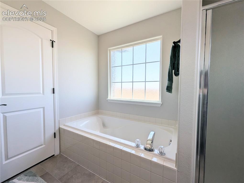 Image 31 of 49: Spacious room featuring vaulted ceilings, a ceiling fan with integrated lig