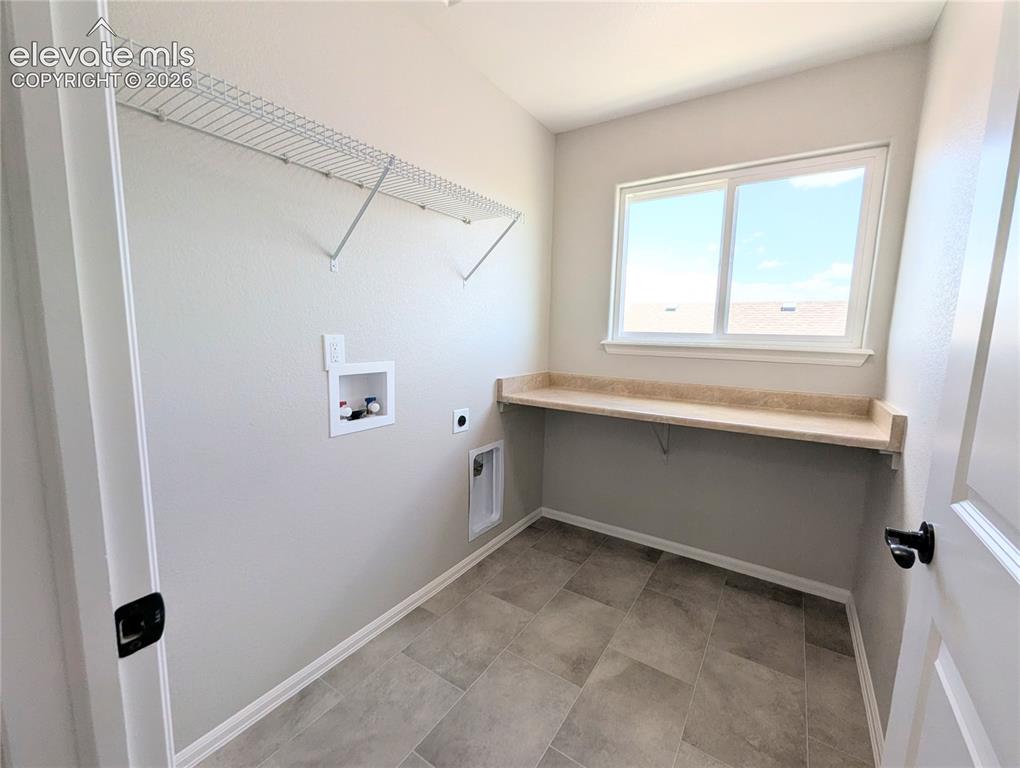 Image 35 of 49: Soaking tub with tile surround, grid-pattern window, and neutral wall tones