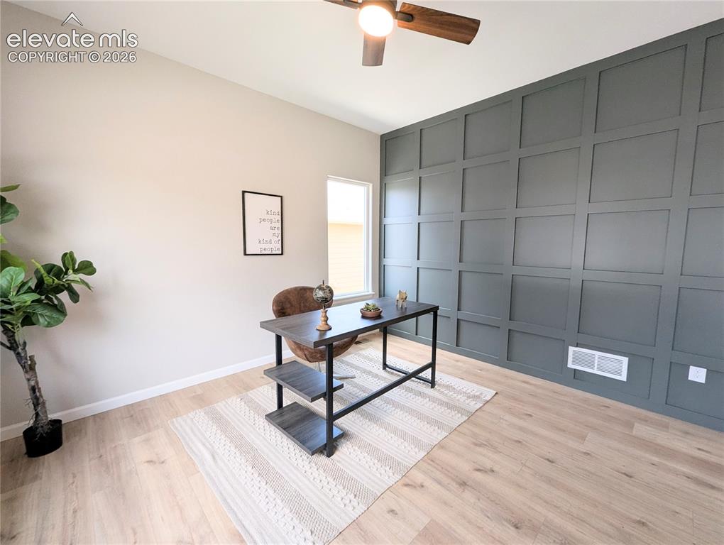 Image 4 of 49: Long hallway featuring wood-finish flooring and light-toned walls