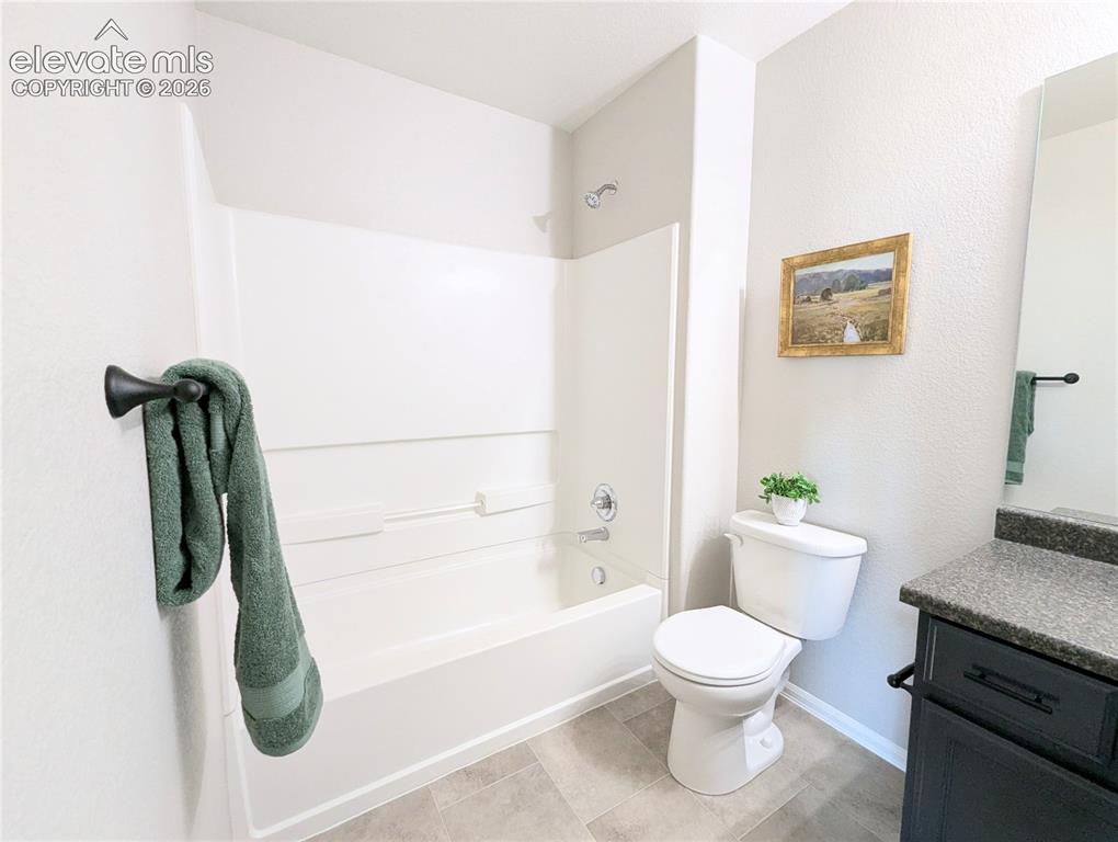 Image 40 of 49: Room featuring a large window, neutral wall paint, and textured gray carpet