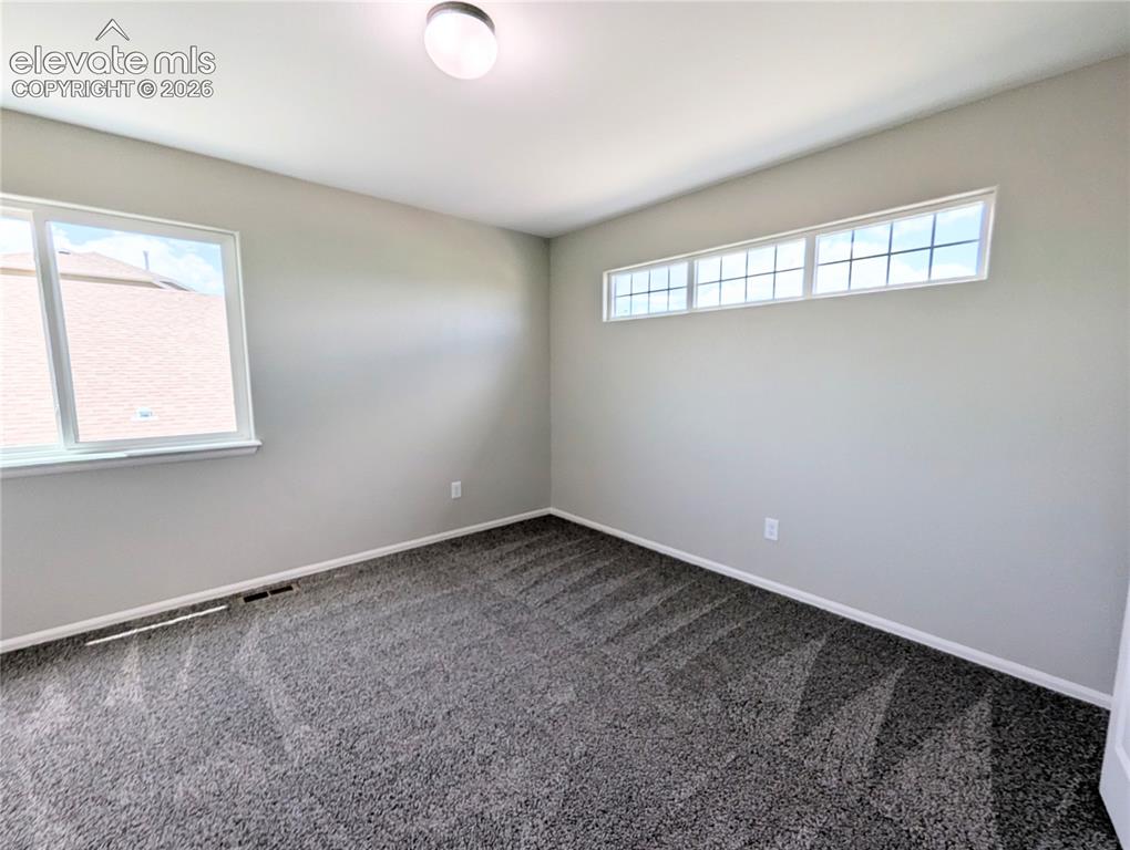 Image 41 of 49: Neutral-toned interior room featuring wall-to-wall carpeting, a flush-mount