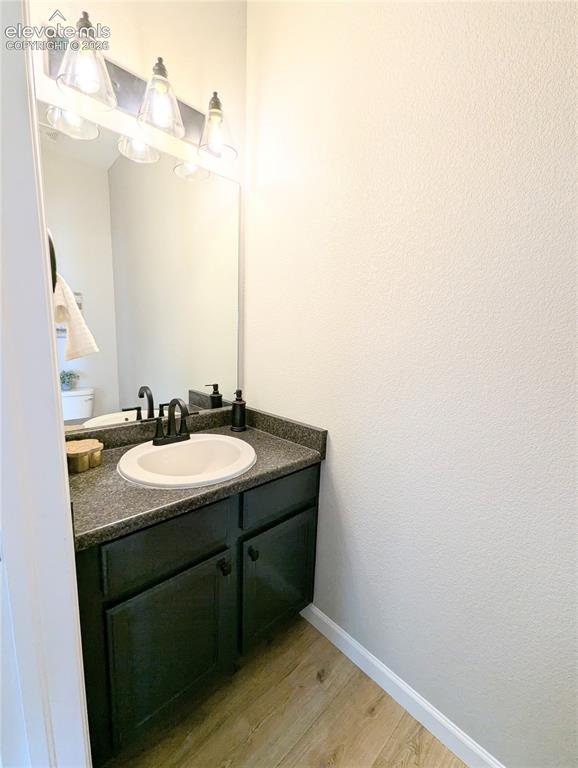 Image 6 of 49: Accent wall with geometric paneling, wood-finish flooring, white window tri