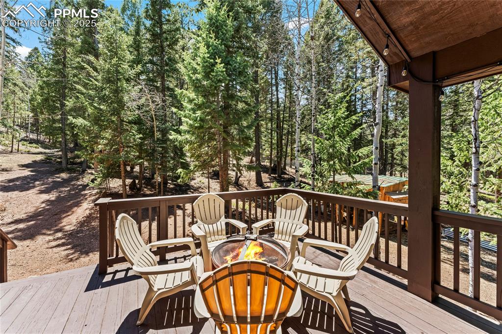 Image 12 of 49: Wooden terrace with an outdoor fire pit