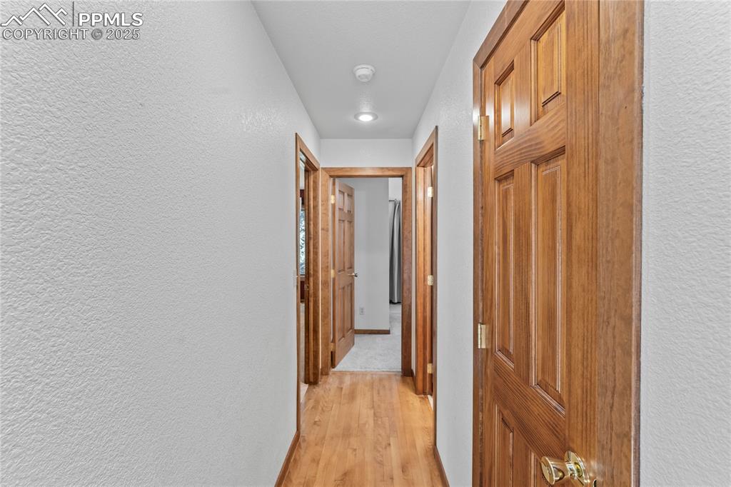 Image 14 of 49: Hallway with a textured wall and light wood-type flooring