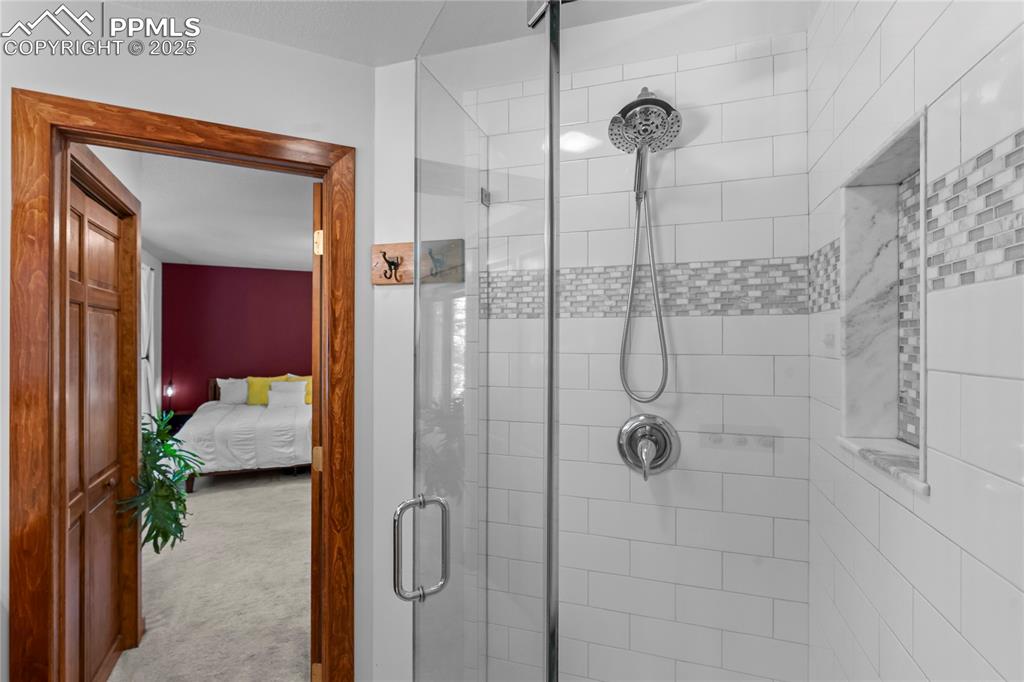 Image 23 of 49: Bathroom featuring a stall shower and ensuite bath
