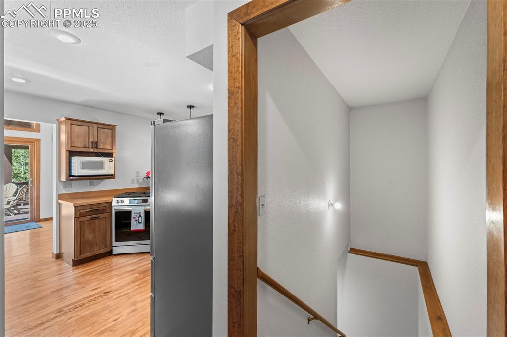 Image 24 of 49: Kitchen with stainless steel appliances, light wood finished floors, light