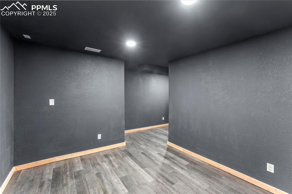 Image 26 of 49: Spare room featuring wood finished floors, recessed lighting, and a texture