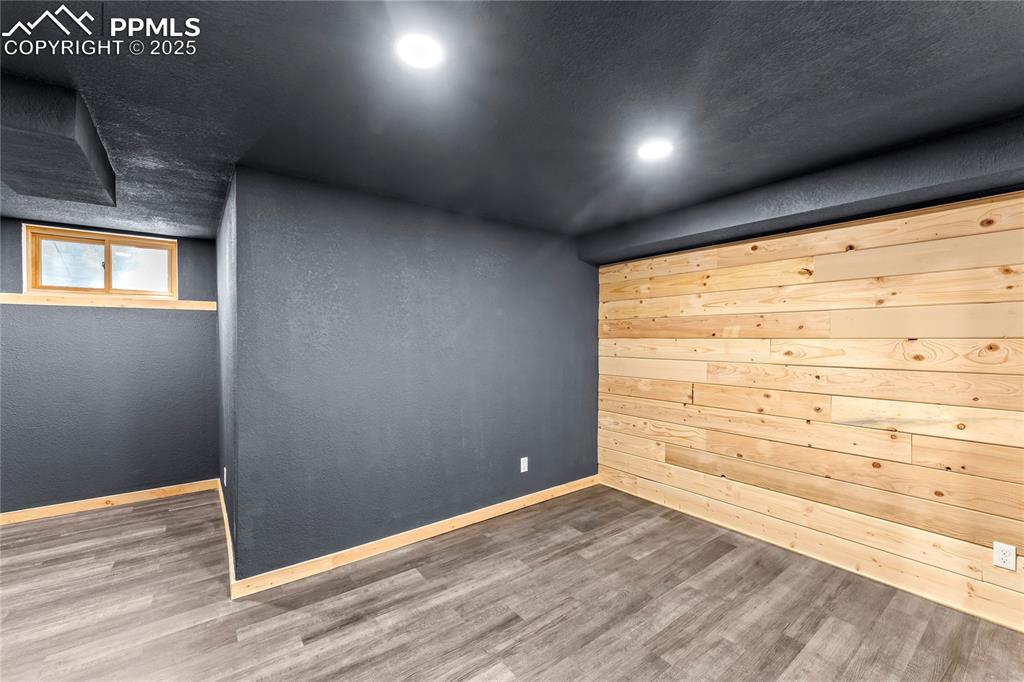 Image 27 of 49: Empty room with wood finished floors and recessed lighting
