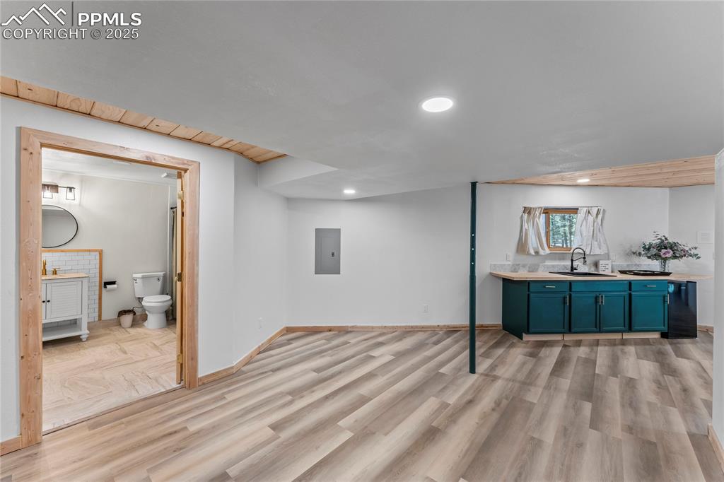 Image 29 of 49: Basement with electric panel, light wood finished floors, and recessed ligh