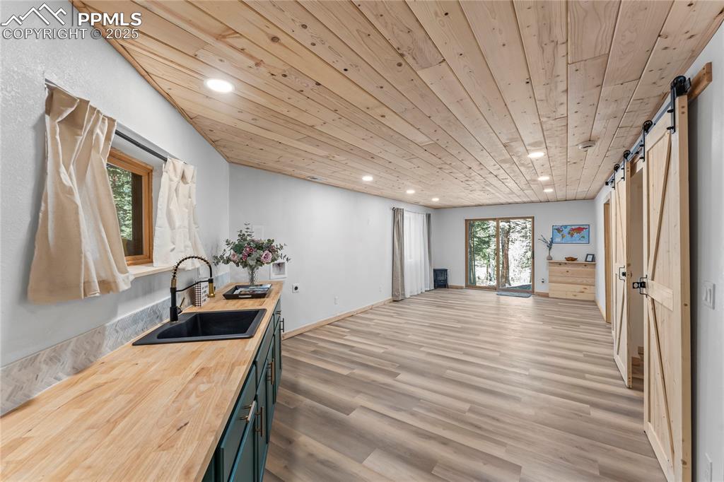Image 32 of 49: Kitchen featuring a barn door, recessed lighting, wooden counters, wooden c