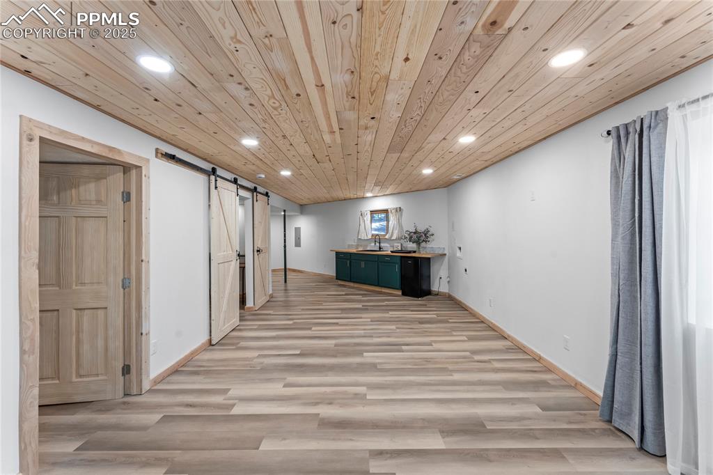 Image 33 of 49: Basement featuring a barn door, recessed lighting, light wood-style floors,