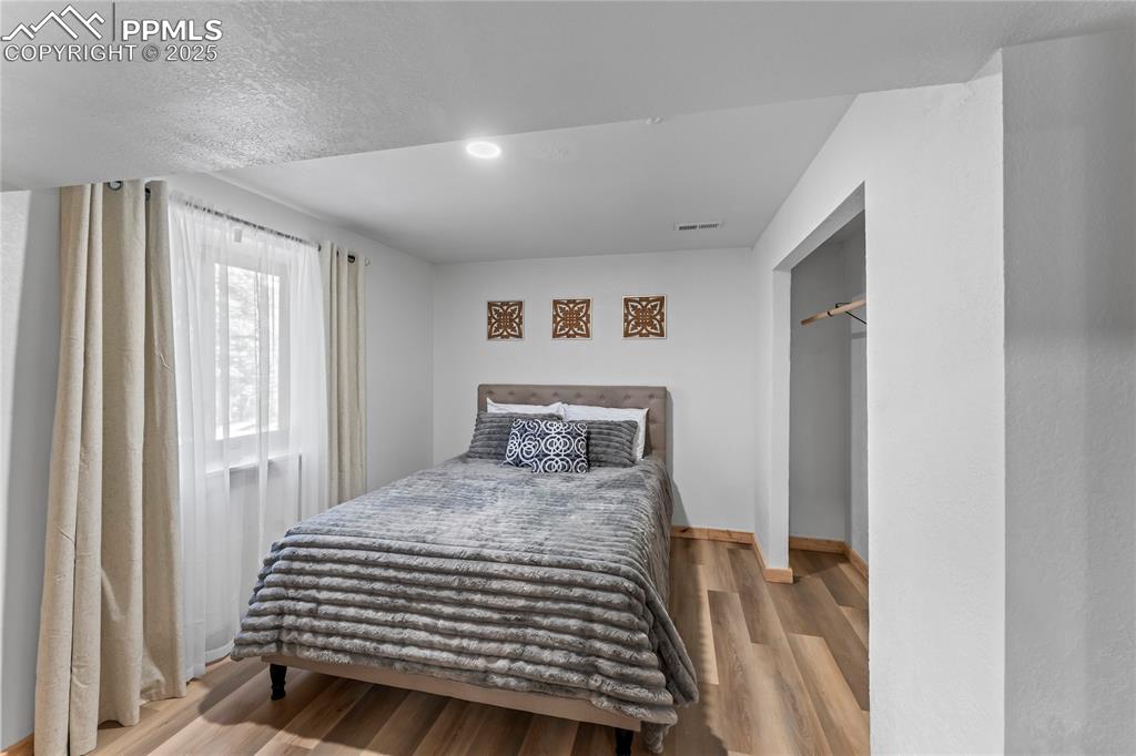 Image 36 of 49: Bedroom with wood finished floors and recessed lighting