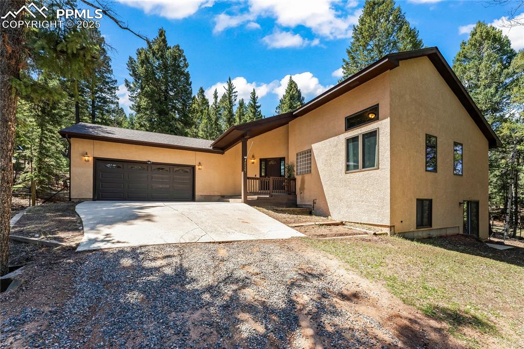 Image 41 of 49: View of front facade with driveway, stucco siding, and a garage