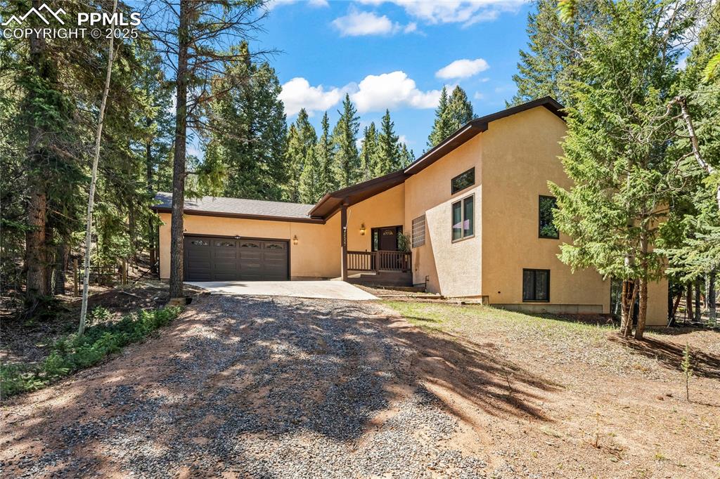 Image 42 of 49: View of front of property featuring driveway, stucco siding, and an attache
