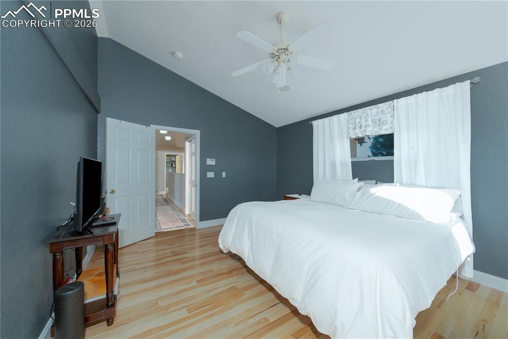 Image 11 of 50: Primary Bedroom featuring lofted ceiling, light wood finished floors, a cei