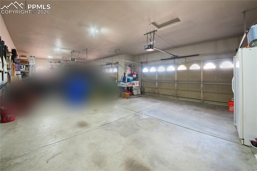 Image 36 of 50: Garage featuring freestanding refrigerator