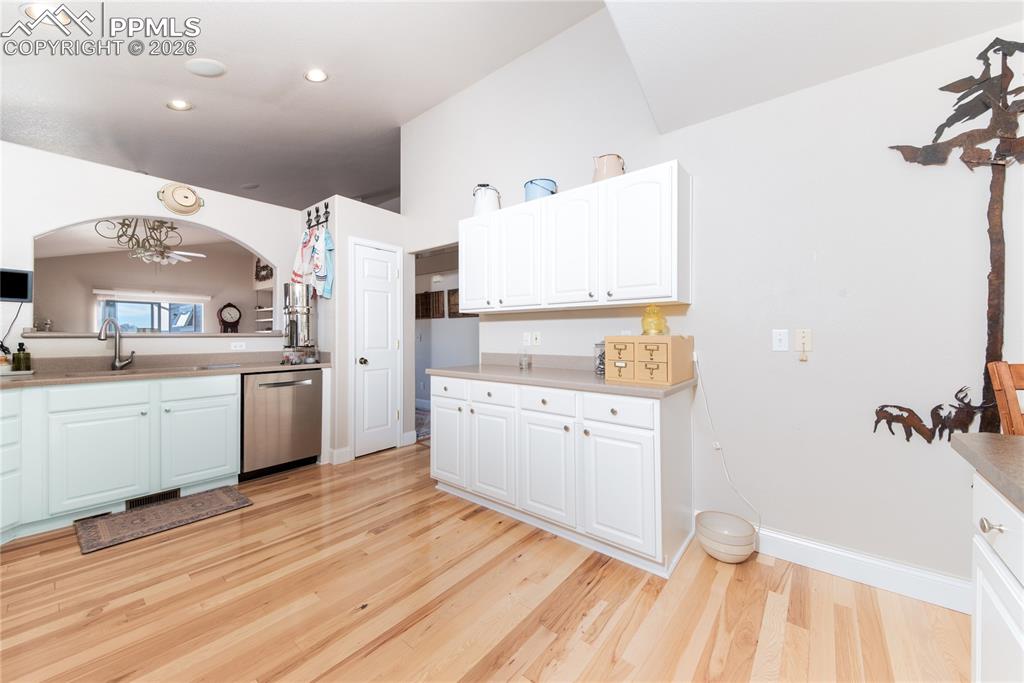 Image 6 of 50: Kitchen with white cabinetry, light wood-type flooring, dishwasher, and lig