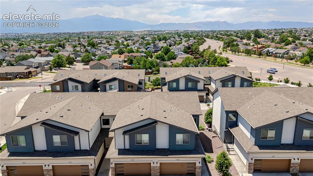 Image 16 of 21: Modern townhome complex featuring multi-toned siding, attached garages, and