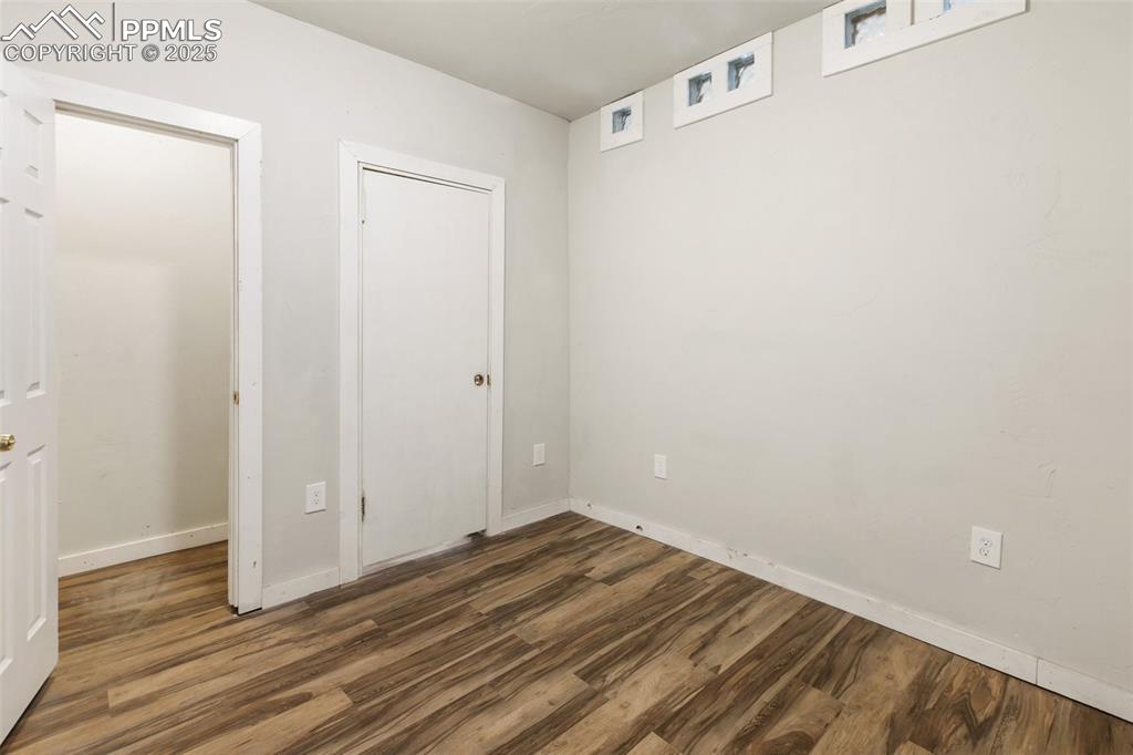 Image 25 of 34: Unfurnished bedroom with dark wood finished floors and baseboards