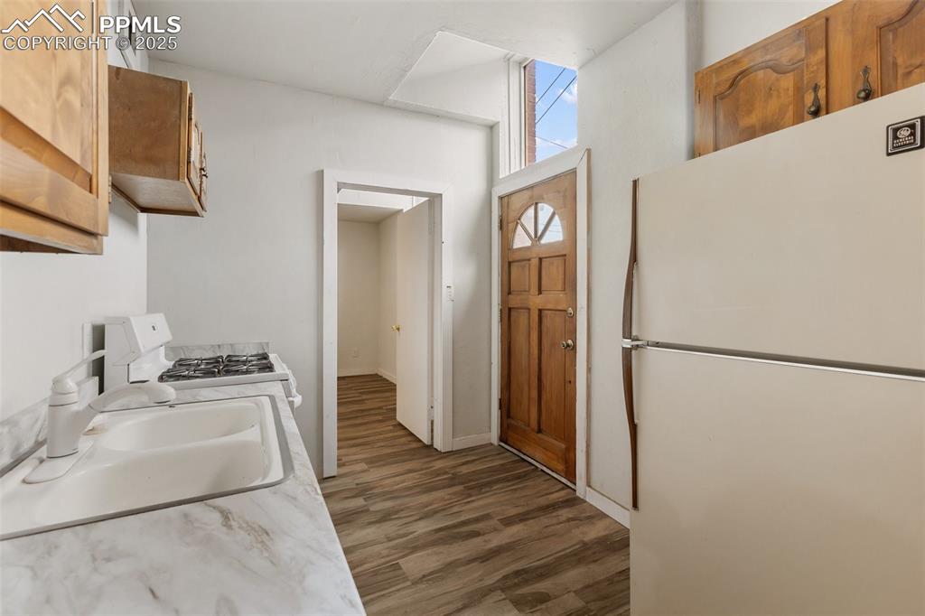 Image 26 of 34: Kitchen featuring white appliances, dark wood-type flooring, light countert
