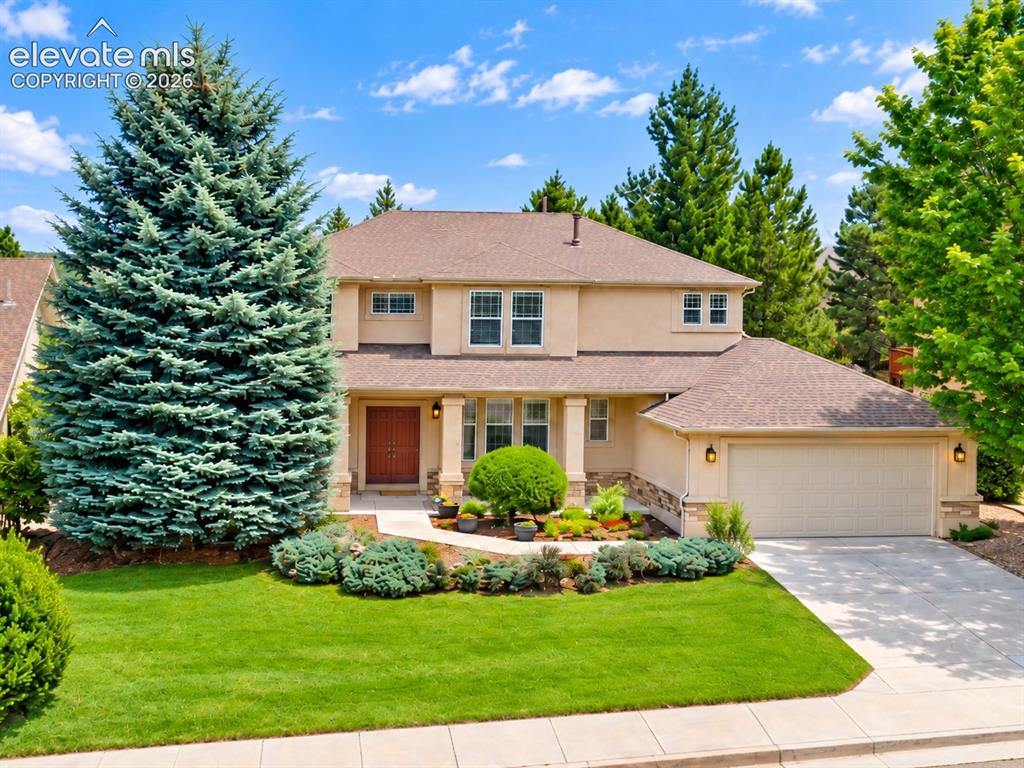 Image 6 of 48: Stucco exterior with a pitched shingle roof, integrated two-car garage, and