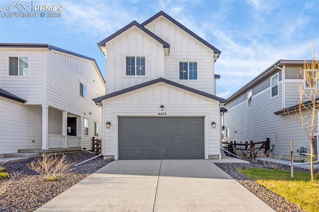 Image 2 of 38: View of front of home featuring board and batten siding, an attached garage