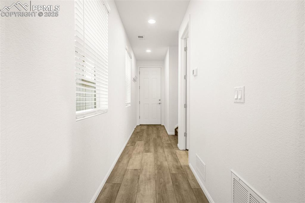 Image 21 of 38: Hall with wood finished floors, recessed lighting, and baseboards
