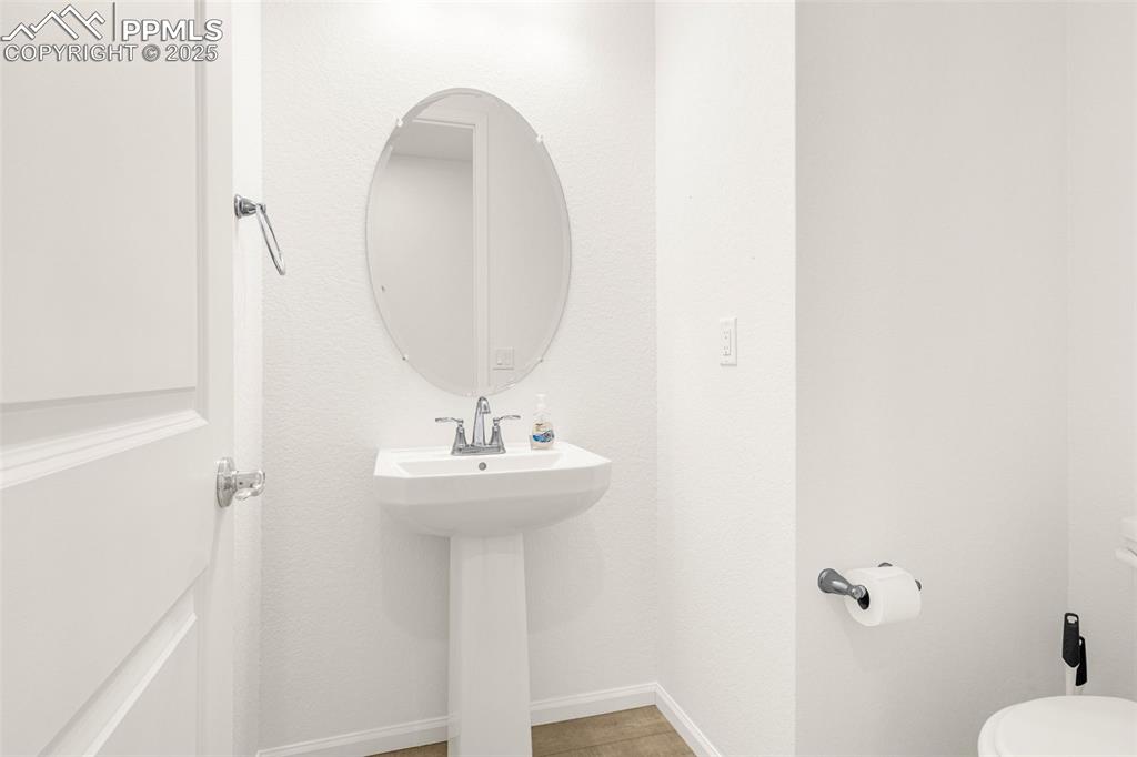 Image 22 of 38: Half bath featuring toilet, baseboards, and a sink