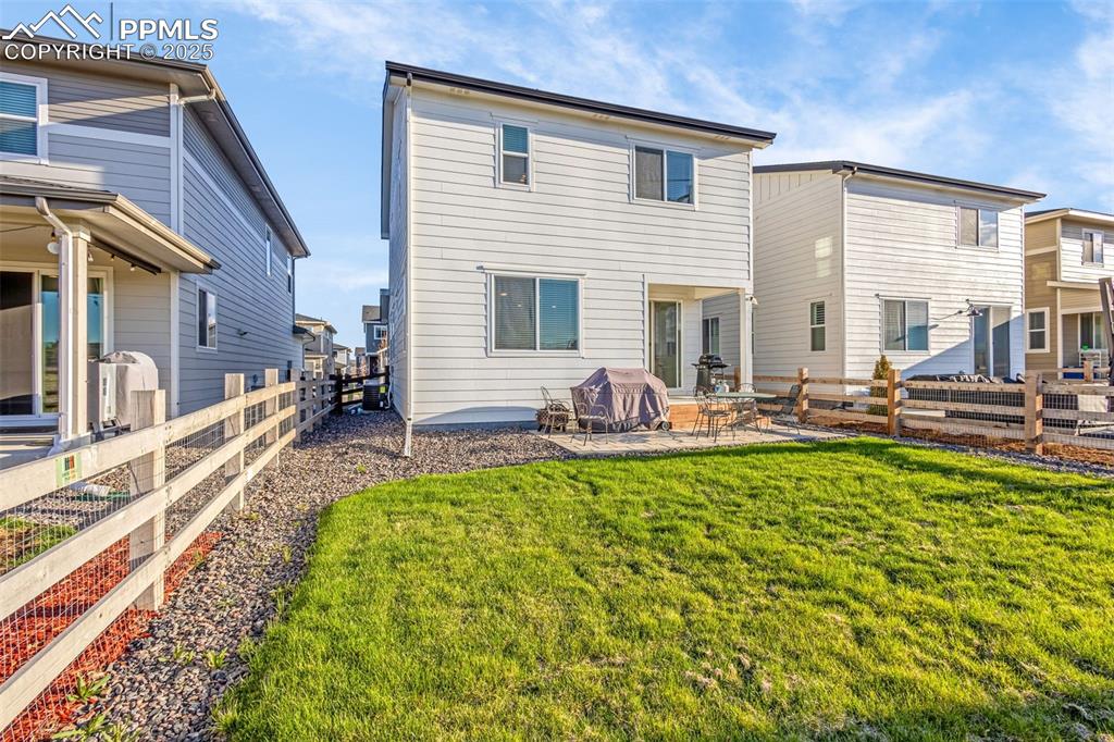 Image 26 of 38: Rear view of house with a patio area