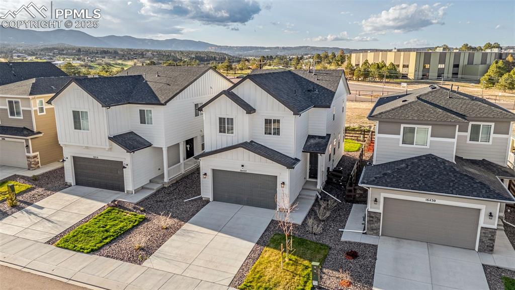 Image 3 of 38: Aerial perspective of suburban area featuring a mountainous background
