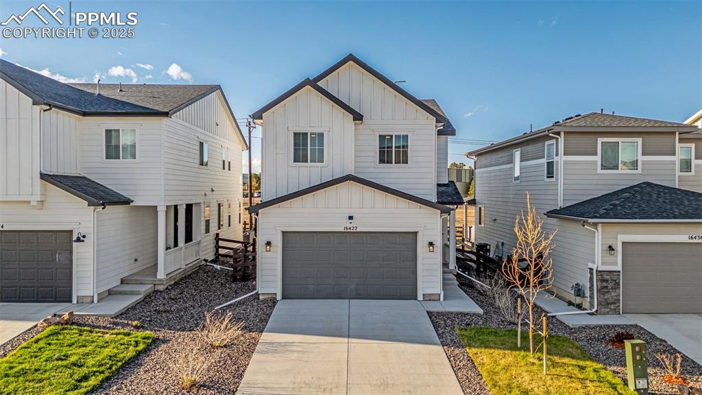 Image 37 of 38: View of front of property featuring board and batten siding, a garage, and