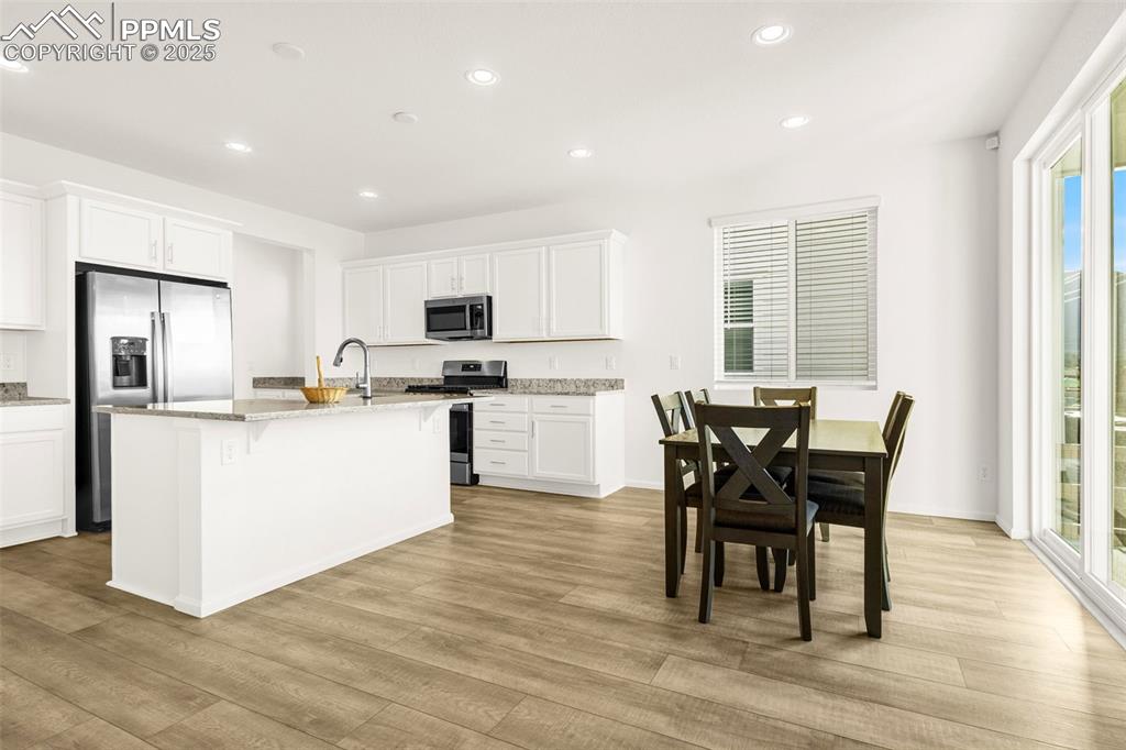 Image 4 of 38: Kitchen with appliances with stainless steel finishes, light wood-style flo