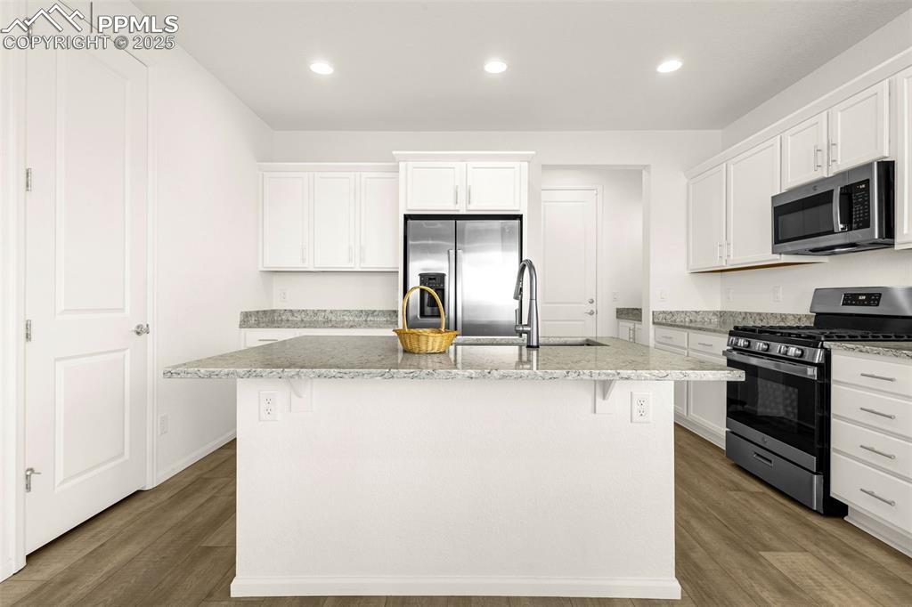 Image 6 of 38: Kitchen featuring appliances with stainless steel finishes, a kitchen islan