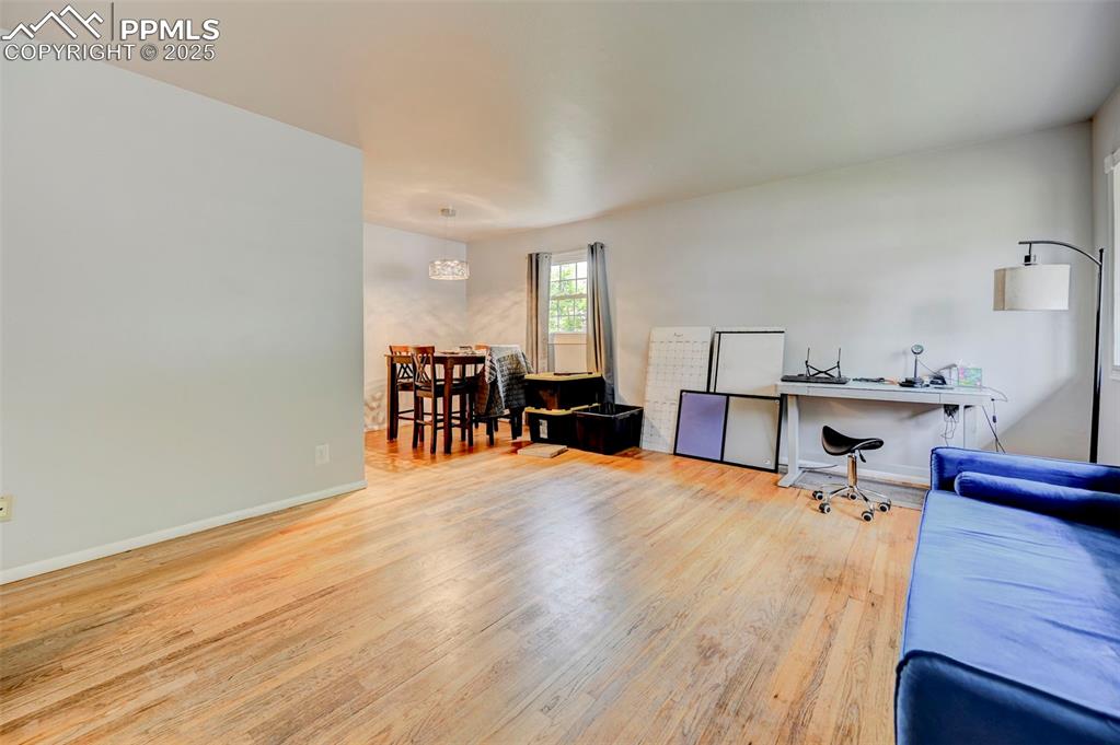 Image 3 of 30: Living room, looking into dining area. Hardwood floors.