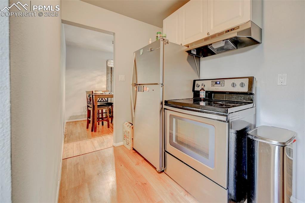 Image 7 of 30: Kitchen with stainless appliances and hardwood floors